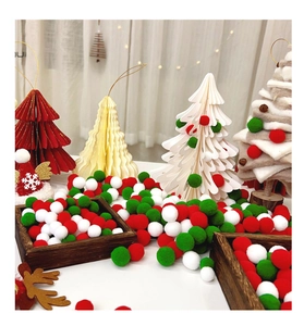 Close-up of red, green, and white fluffy pompoms with miniature felt Christmas trees