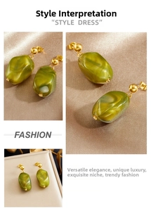 Close-up of olive green resin geometric pendant with gold stud on champagne satin background