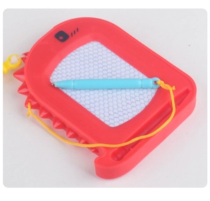 Macro shot of red dinosaur magnetic drawing board with stylus and honeycomb grid screen