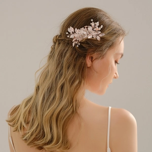 Rose gold bridal hair comb with pearls and rhinestones on blonde wavy hair