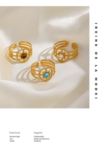 Detailed close-up of three vintage gold rings with malachite and turquoise on white silk