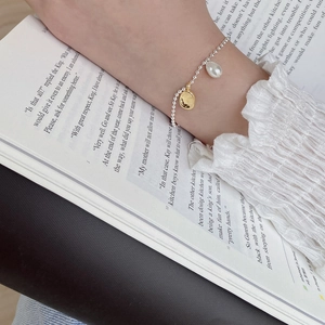 Elegant S925 silver beaded bracelet with baroque pearl and gold charm on female wrist