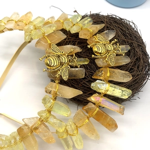 Detailed close-up of handmade crystal headband with gold bees on a rustic bird nest
