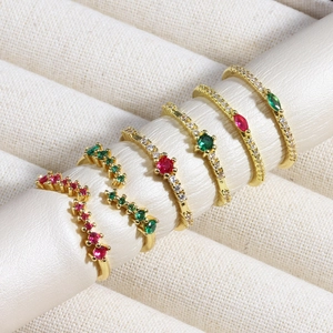 Luxurious gold rings set with emerald and ruby zircon stones on a display stand