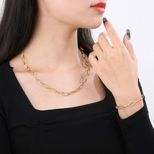 Minimalist gold geometric hexagon link necklace and bracelet set worn by a model