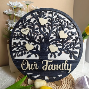 Close-up of wooden family tree plaque with heart name charms and Our Family banner