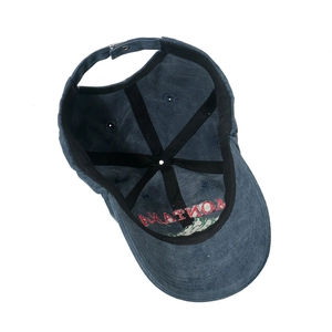 Detail showing the inner structure, top stitching, and metal buckle of the navy baseball cap