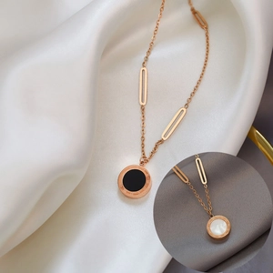 Rose gold Roman numeral necklace with black and white shells on elegant silk fabric