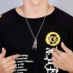 Close-up of a men's steel necklace with a skull-engraved power plug pendant on a male model