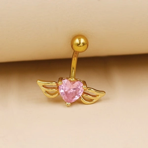 Détail d'un piercing nombril doré avec pierre de cœur rose et ailes ajourées