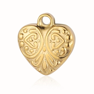 Macro view of a gold heart-shaped pendant with embossed vintage eye pattern