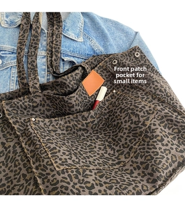 Detail of leopard print tote bag featuring a front pocket for small item storage