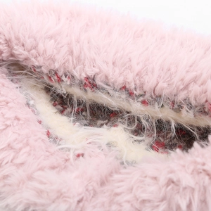 Détail de l'extérieur en fausse fourrure rose et doublure polaire crème du bonnet