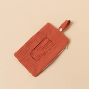 Detail of baby wipes storage bag in orange cotton crepe with hanging strap and zipper
