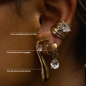 Detailed view of luxe gold earrings set with pear-shaped cubic zirconia on model