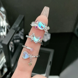 Macro detail of silver rings featuring iridescent moonstones and pink gemstone accents