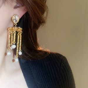 Vue détaillée de boucles d'oreilles vintage avec cristal goutte et perles sur modèle