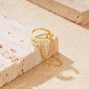 Macro detail of gold-plated S925 silver ear cuff with zircon inlay and fringe chains