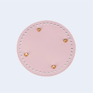 Macro view of pink round PU leather bag base with golden feet and pre-punched holes