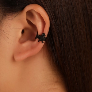 Macro detail of a gothic black bat ear cuff accessory worn on the upper ear cartilage