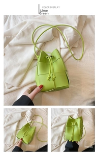 Detail of lime green woven drawstring bucket bag with slender shoulder strap