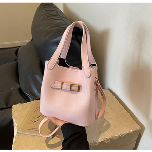 Detail view of pink lychee leather bucket bag with golden buckle and textured handle
