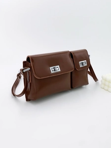 Dark brown leather baguette bag with dual compartments and silver twist lock on white base