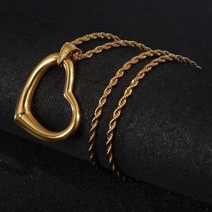 Detail of a minimalist gold hollow heart pendant necklace with twisted rope chain