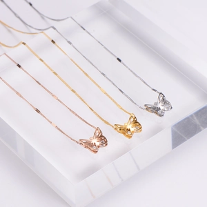 Three-color hollow butterfly pendant necklace with crystal inlay on a display stand