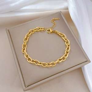 Minimalist 18K gold-plated titanium steel chain bracelet with textured links on silk