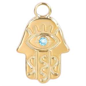 Gros plan du pendentif main de fatma doré orné d'une pierre de zircon bleu brillant