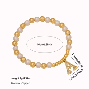 Detail view of elastic beaded bracelet with gold beads, pearls and letter A pendant