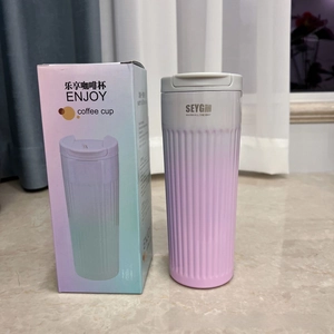 Close-up of pink gradient coffee mug with vertical textures and retail gift box packaging