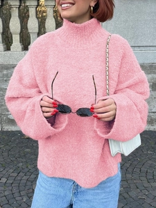 Détail d'un pull en maille rose à col roulé avec tissu texturé et coupe décontractée
