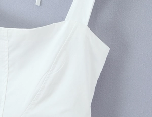 Detail of square neckline and wide shoulder straps on a white boned corset dress