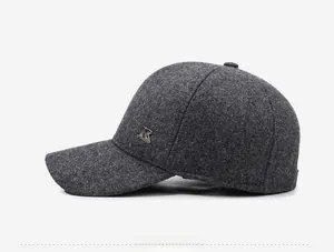 Detail view of the dark grey wool blend baseball cap with a silver metal brand logo