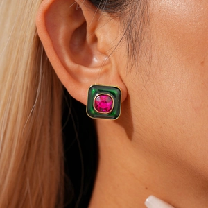 Gros plan détaillé sur boucle d'oreille vintage en émail vert et pierre carrée rose