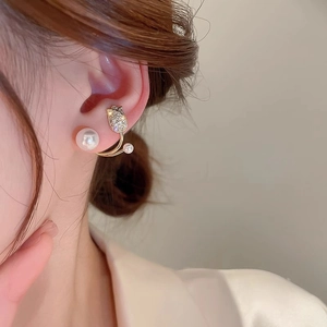 Close-up of elegant gold tulip earrings featuring small diamonds and white pearls
