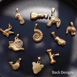 Set of 11 assorted 18K gold plated titanium steel animal pendants on a black tray