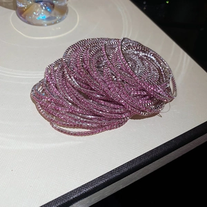 Macro shot of layered pink crystal rhinestone bracelets with silver metal claw setting