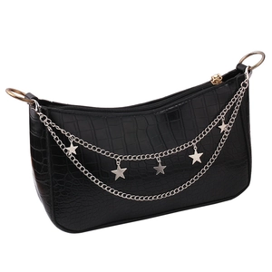 Detail of black faux crocodile skin texture with silver star charm and chain decoration