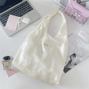 Detail of white pearlescent fabric tote bag with glossy finish and Sozakka brand tag