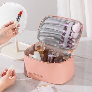 Pink PU leather cosmetic bag with gold zipper and compartments for makeup organization