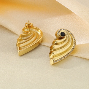 Detail of gold shell-textured earrings with black center stone and sparkling rhinestones