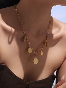Close-up of vintage gold coin necklace with five pendants on an elegant paperclip chain