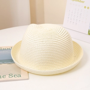 Détail d'un chapeau de soleil beige tressé avec oreilles de chat et bord roulé pour enfant
