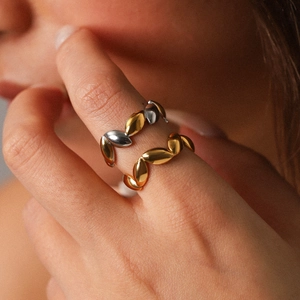 Minimalist gold and two-tone stainless steel leaf open rings set on model hand