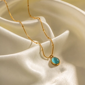 18K gold plated stainless steel necklace with oval sky blue cat-eye stone on white silk