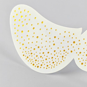 Close-up of golden faux freckle patches with elegant metallic speckled pattern detail