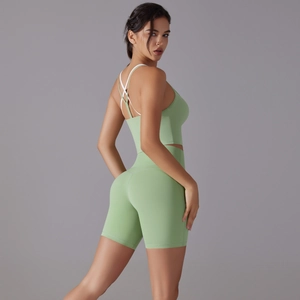 Women's two-piece yoga set with green crop top and high-waisted shorts in studio